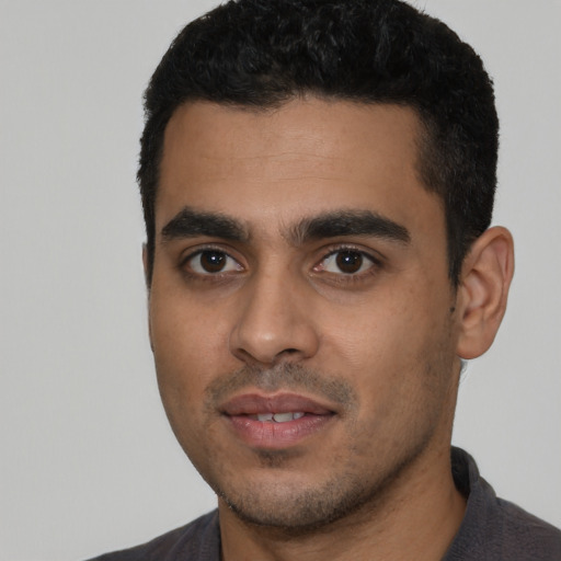 Joyful latino young-adult male with short  black hair and brown eyes