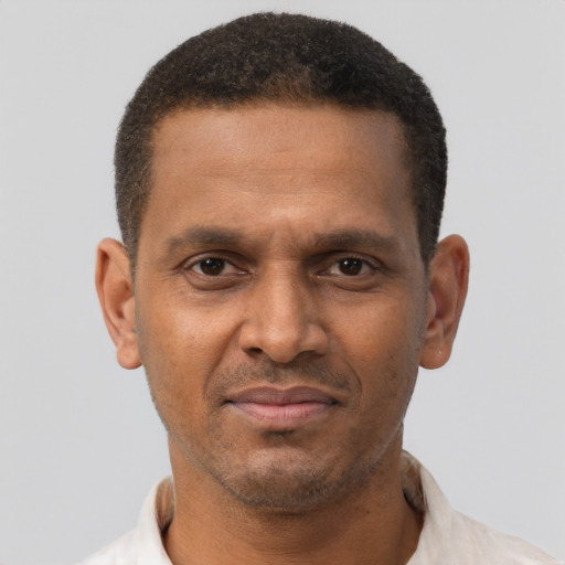 Joyful black young-adult male with short  brown hair and brown eyes