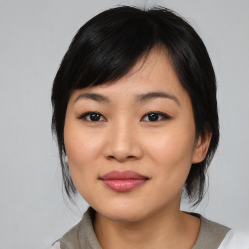Joyful asian young-adult female with medium  black hair and brown eyes