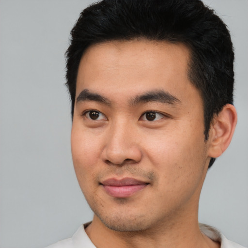 Joyful asian young-adult male with short  black hair and brown eyes