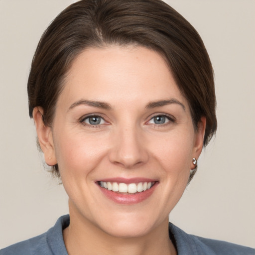 Joyful white young-adult female with short  brown hair and grey eyes