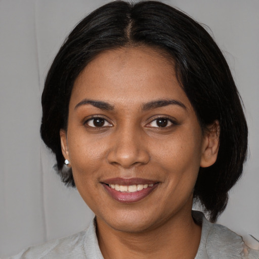 Joyful black young-adult female with medium  brown hair and brown eyes