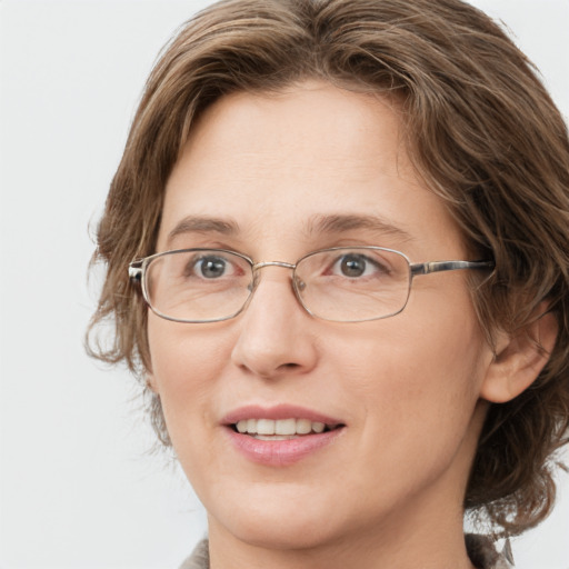 Joyful white adult female with medium  brown hair and green eyes