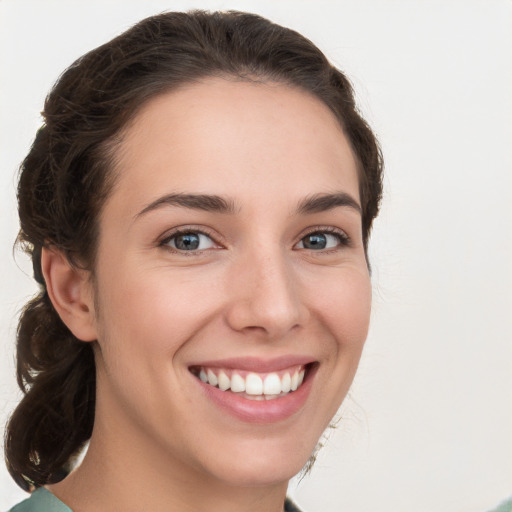 Joyful white young-adult female with medium  brown hair and green eyes