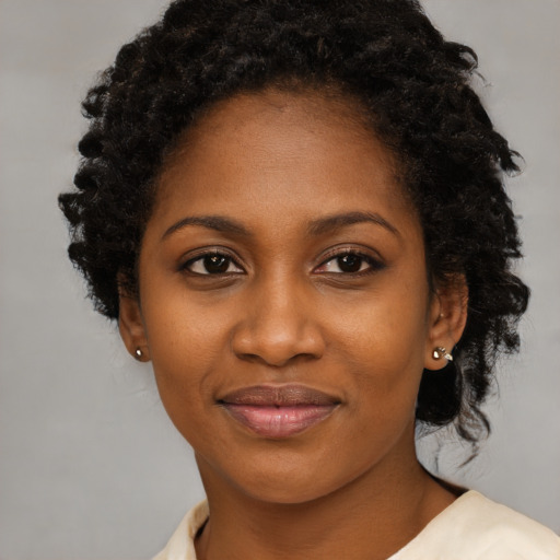 Joyful black young-adult female with medium  black hair and brown eyes