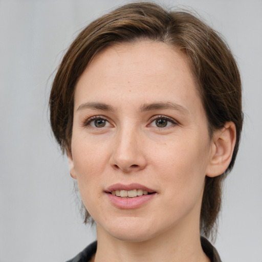 Joyful white young-adult female with medium  brown hair and grey eyes