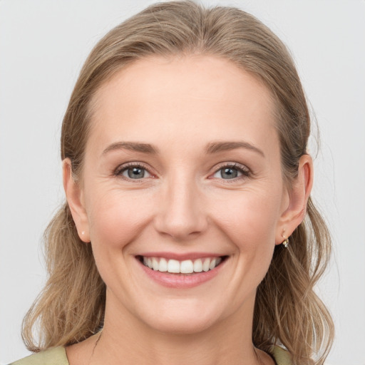 Joyful white young-adult female with medium  brown hair and grey eyes