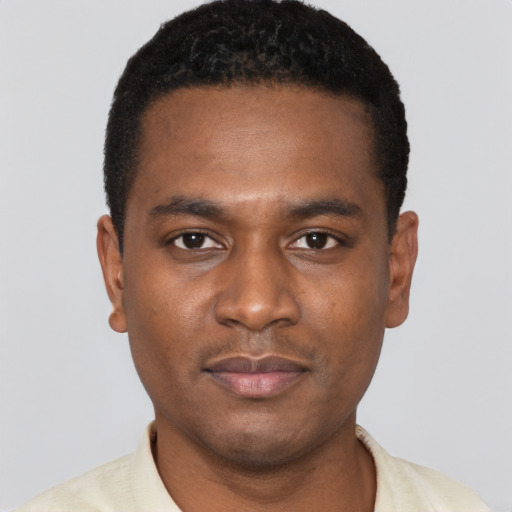 Joyful black young-adult male with short  black hair and brown eyes