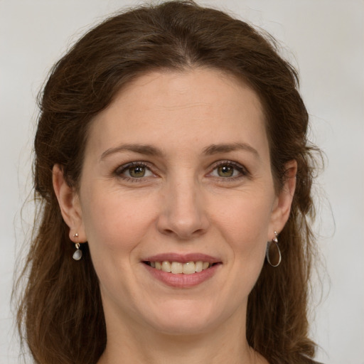 Joyful white young-adult female with long  brown hair and green eyes