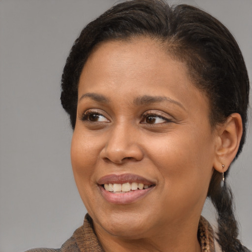 Joyful latino adult female with medium  brown hair and brown eyes