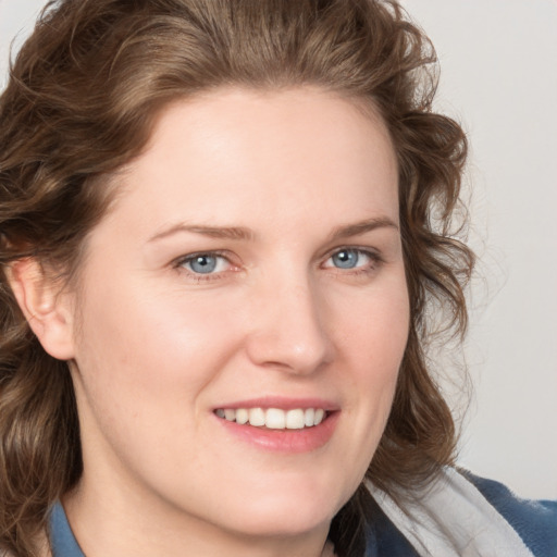 Joyful white young-adult female with medium  brown hair and blue eyes