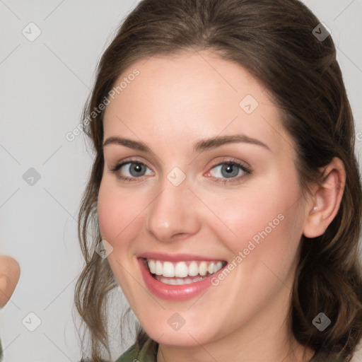 Joyful white young-adult female with medium  brown hair and green eyes