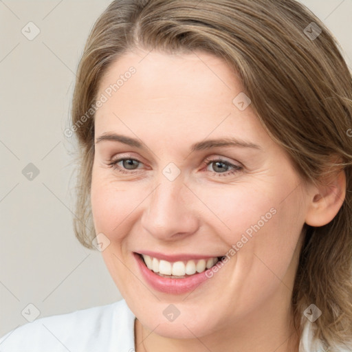 Joyful white young-adult female with medium  brown hair and grey eyes