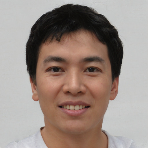 Joyful asian young-adult male with short  black hair and brown eyes