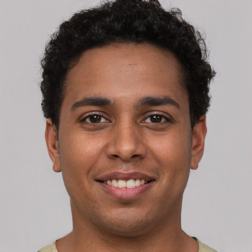 Joyful latino young-adult male with short  brown hair and brown eyes