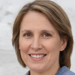 Joyful white adult female with medium  brown hair and grey eyes