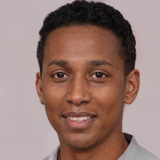 Joyful black young-adult male with short  black hair and brown eyes