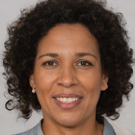 Joyful black adult female with medium  brown hair and brown eyes