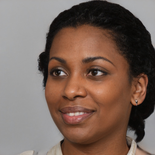 Joyful black young-adult female with medium  black hair and brown eyes