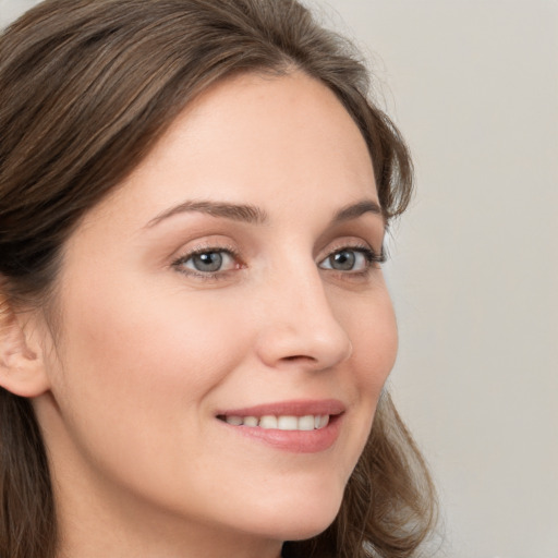 Joyful white young-adult female with long  brown hair and grey eyes