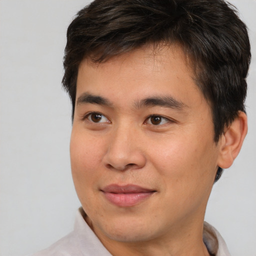 Joyful asian young-adult male with short  brown hair and brown eyes