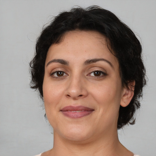Joyful latino adult female with medium  brown hair and brown eyes