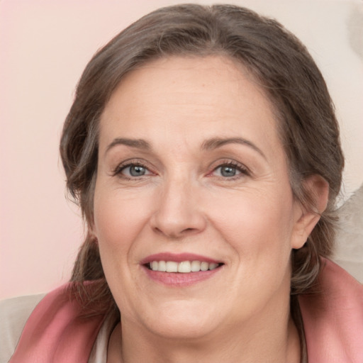 Joyful white adult female with medium  brown hair and grey eyes