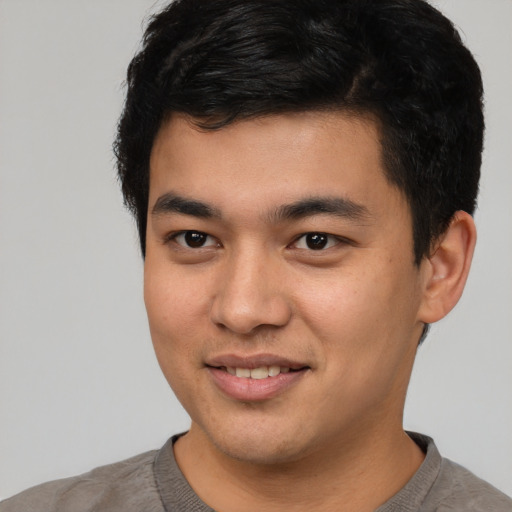 Joyful asian young-adult male with short  black hair and brown eyes