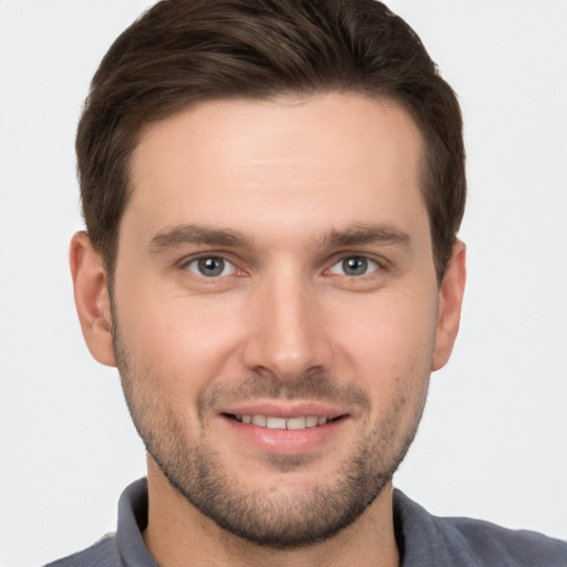 Joyful white young-adult male with short  brown hair and grey eyes