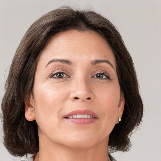 Joyful white adult female with medium  brown hair and grey eyes