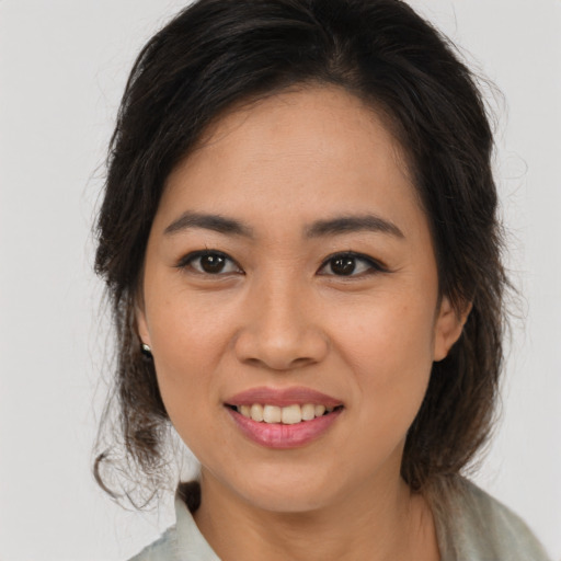 Joyful latino young-adult female with medium  brown hair and brown eyes