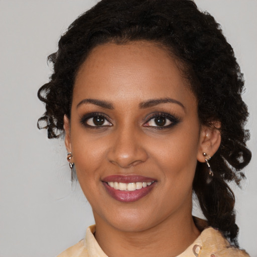 Joyful black young-adult female with medium  brown hair and brown eyes