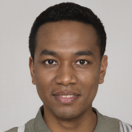 Joyful black young-adult male with short  black hair and brown eyes