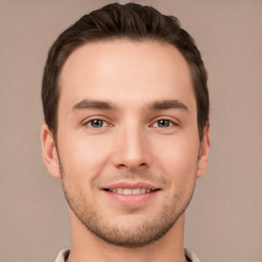 Joyful white young-adult male with short  brown hair and grey eyes