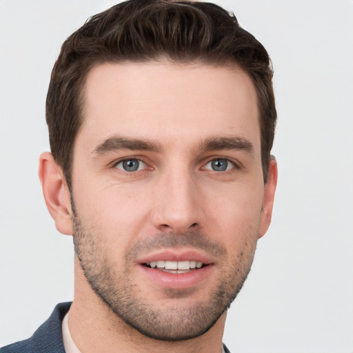 Joyful white young-adult male with short  brown hair and grey eyes