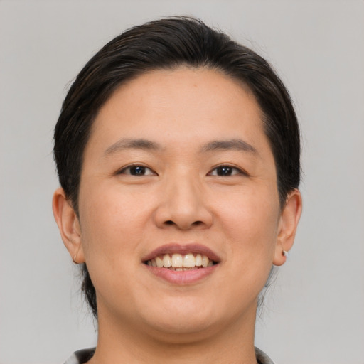 Joyful asian young-adult female with short  brown hair and brown eyes