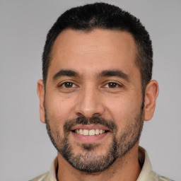 Joyful white adult male with short  black hair and brown eyes