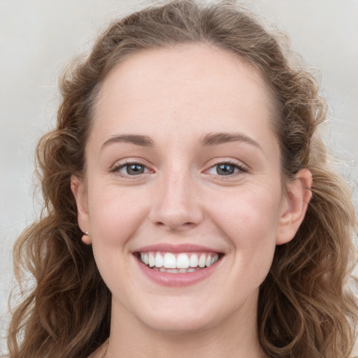 Joyful white young-adult female with long  brown hair and blue eyes