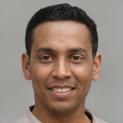 Joyful latino young-adult male with short  black hair and brown eyes