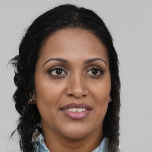 Joyful black young-adult female with long  brown hair and brown eyes