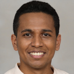 Joyful latino young-adult male with short  brown hair and brown eyes