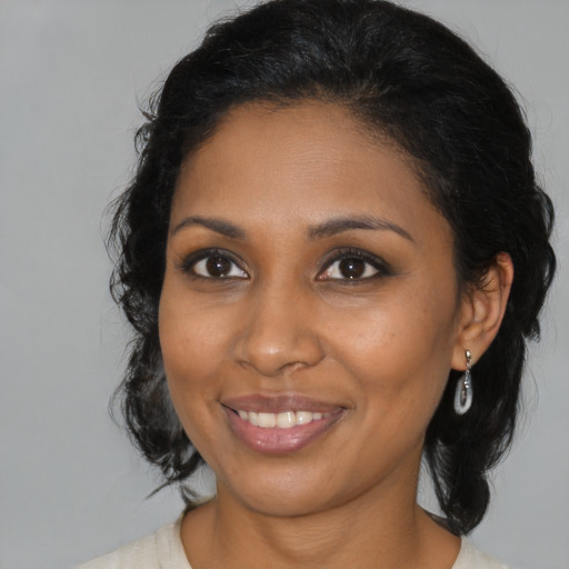Joyful black young-adult female with medium  black hair and brown eyes