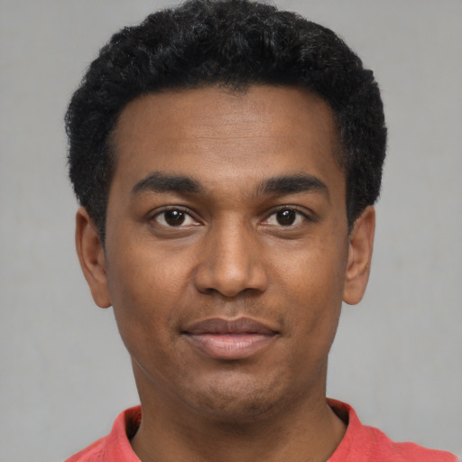 Joyful black young-adult male with short  black hair and brown eyes