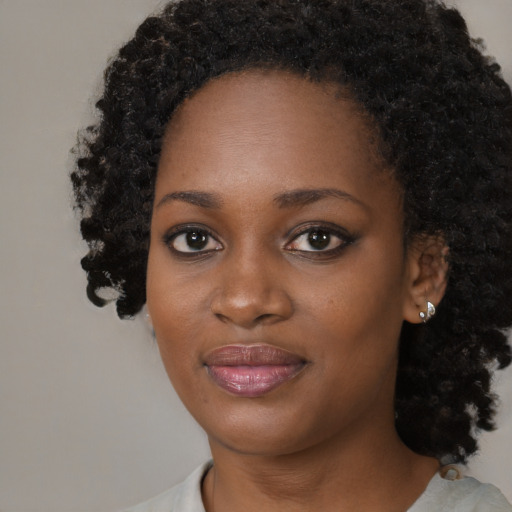 Joyful black young-adult female with medium  black hair and brown eyes