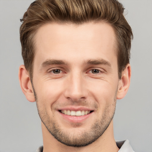 Joyful white young-adult male with short  brown hair and grey eyes