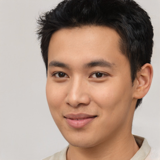 Joyful asian young-adult male with short  black hair and brown eyes
