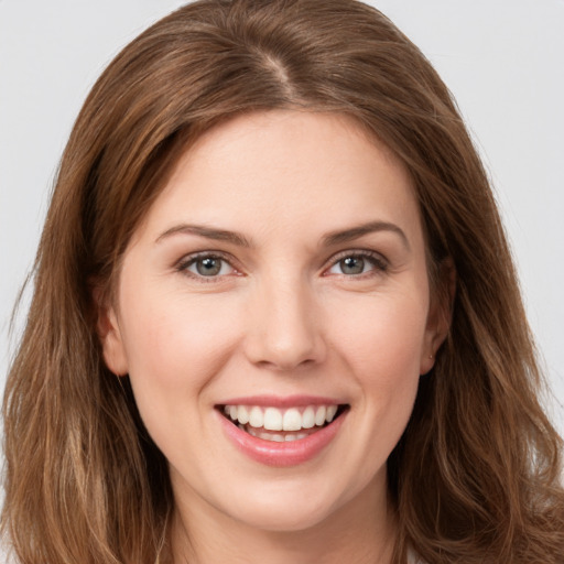 Joyful white young-adult female with long  brown hair and grey eyes