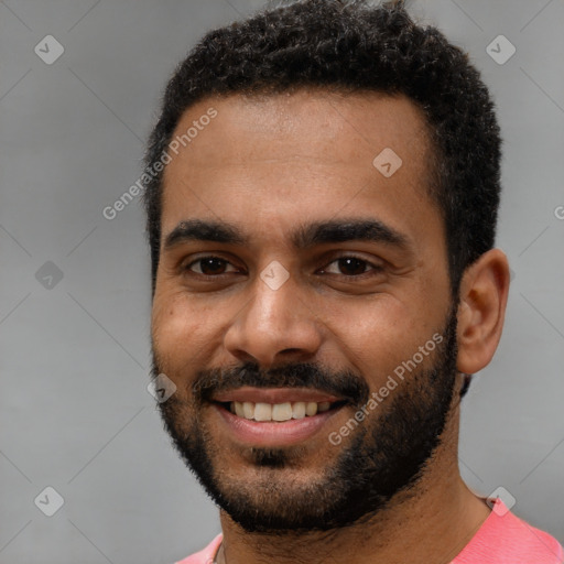 Joyful black young-adult male with short  black hair and brown eyes