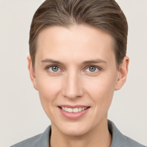 Joyful white young-adult female with short  brown hair and grey eyes