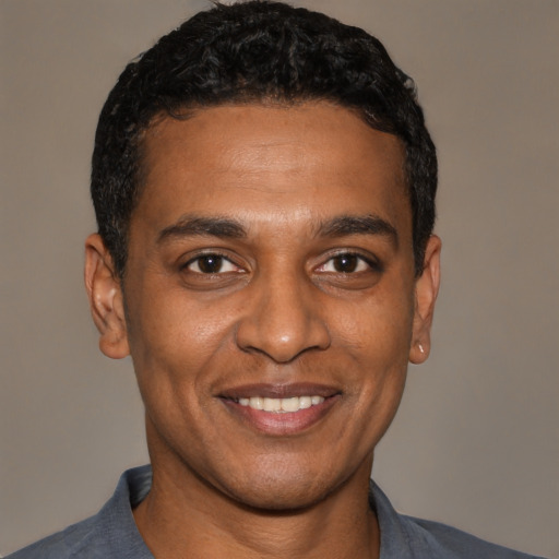 Joyful black young-adult male with short  black hair and brown eyes